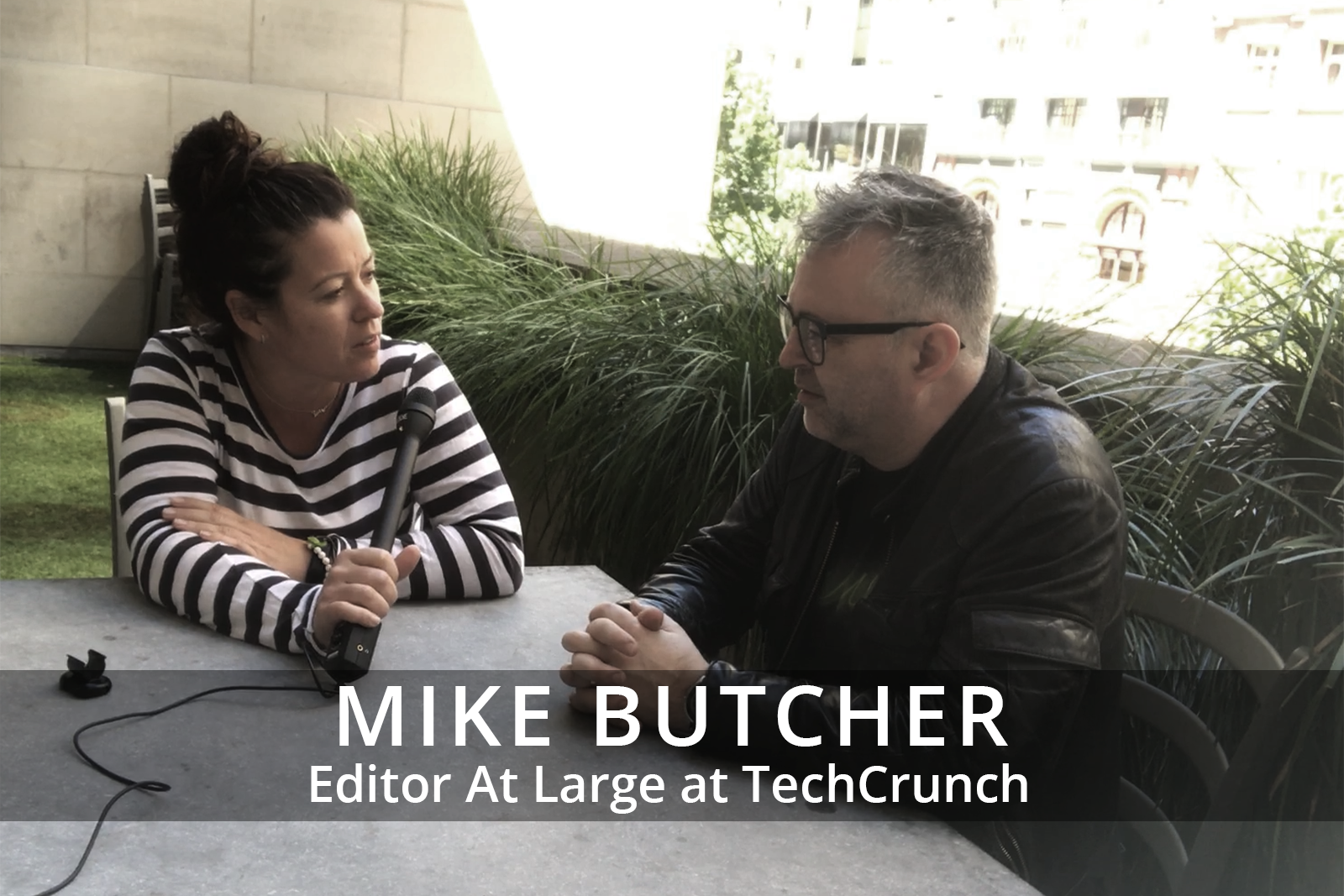 Female participants in a workshop sit in front of a graffiti wall.