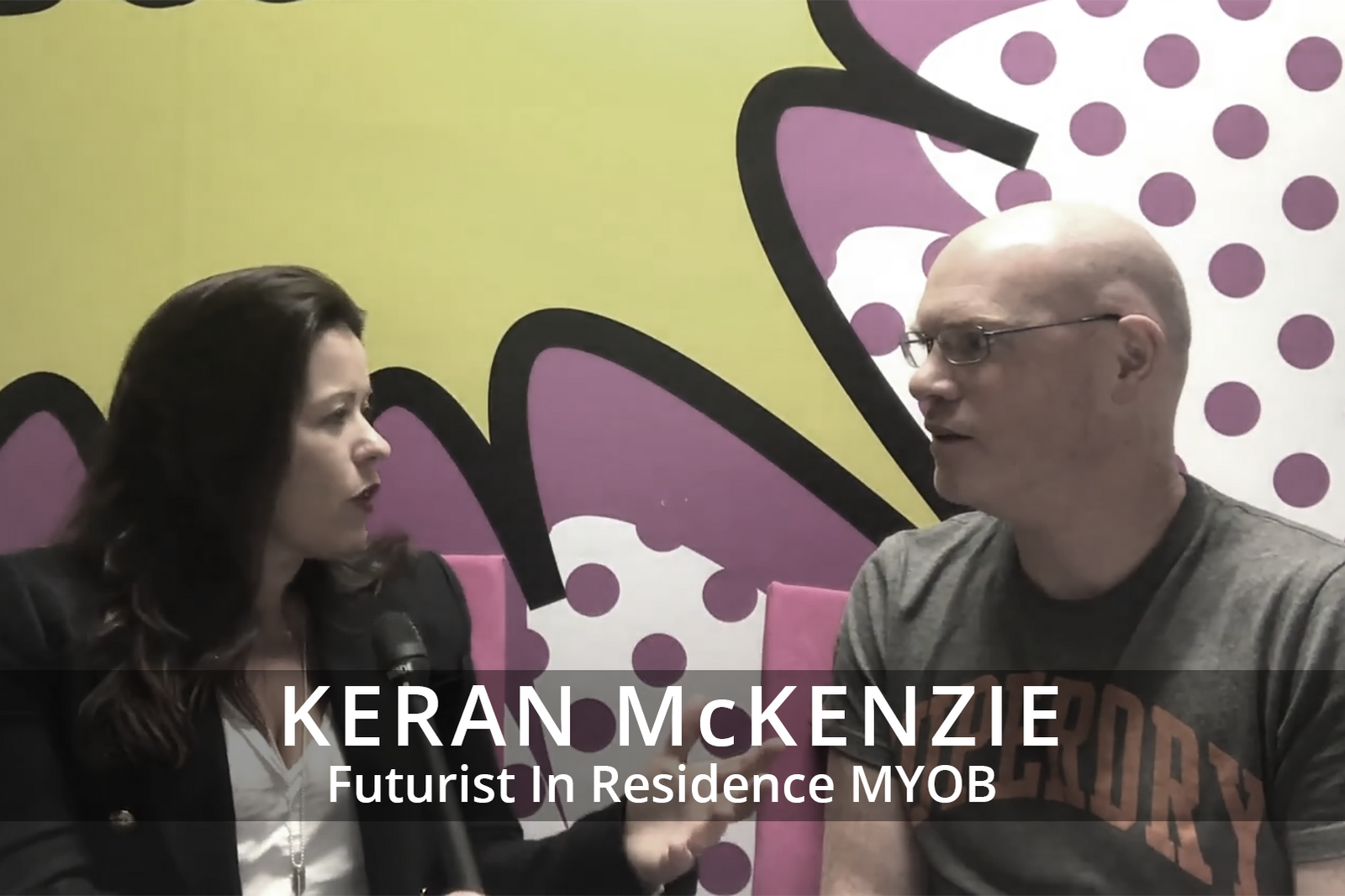 Female participants in a workshop sit in front of a graffiti wall.