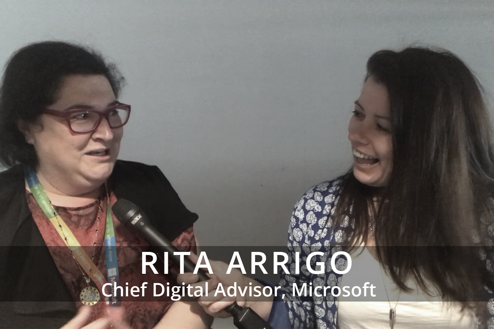 Female participants in a workshop sit in front of a graffiti wall.