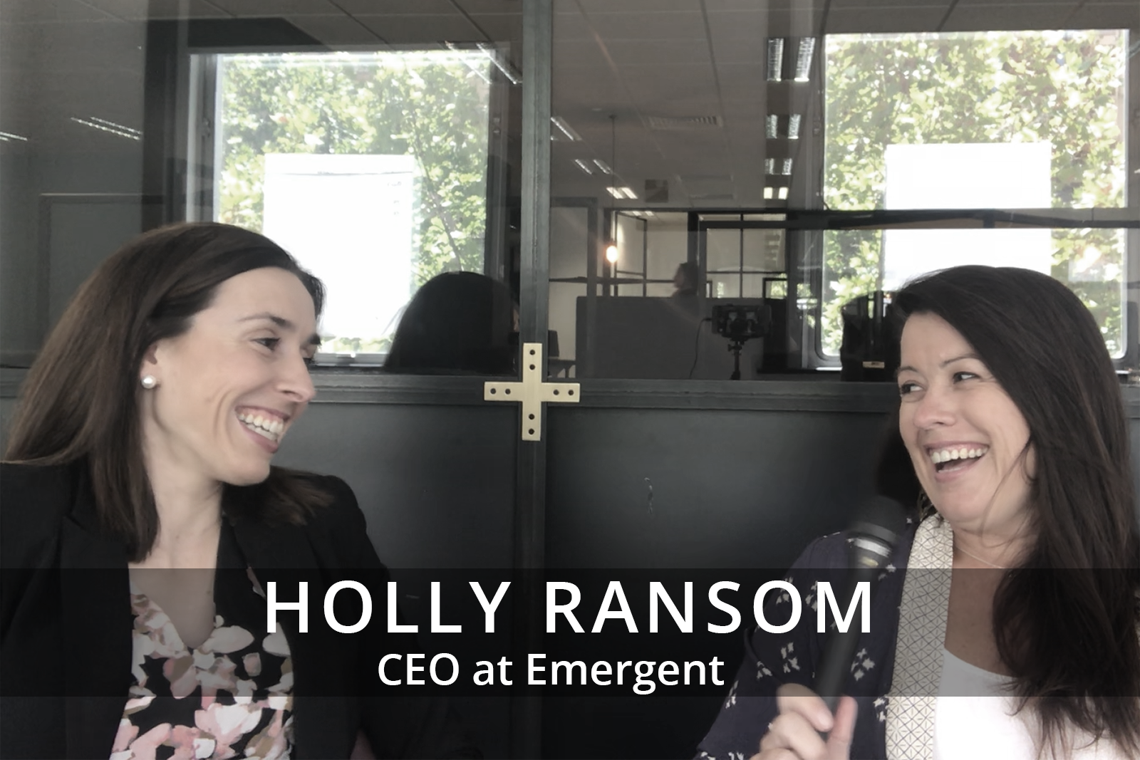 Female participants in a workshop sit in front of a graffiti wall.