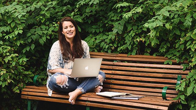 Female participants in a workshop sit in front of a graffiti wall.