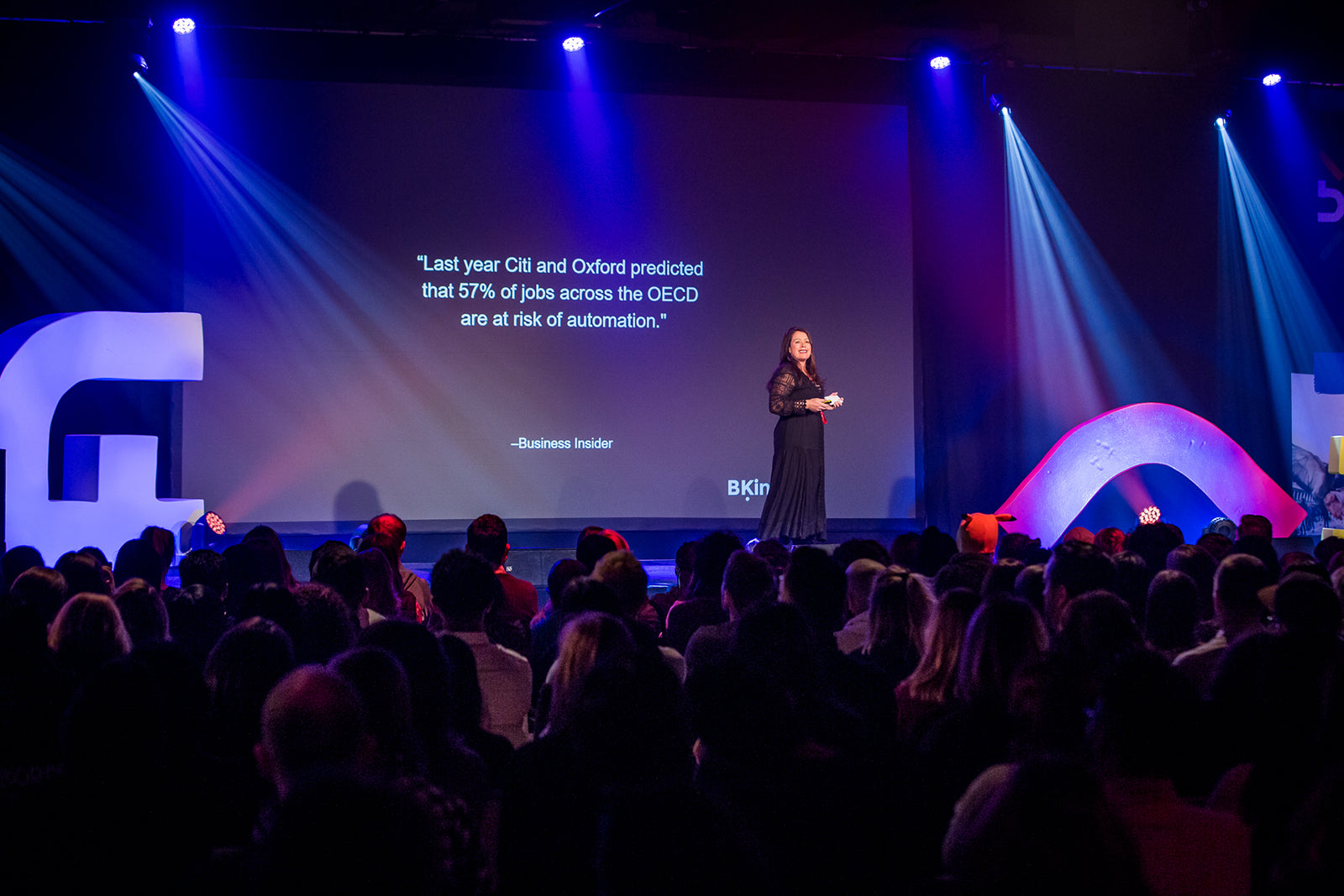 Female participants in a workshop sit in front of a graffiti wall.