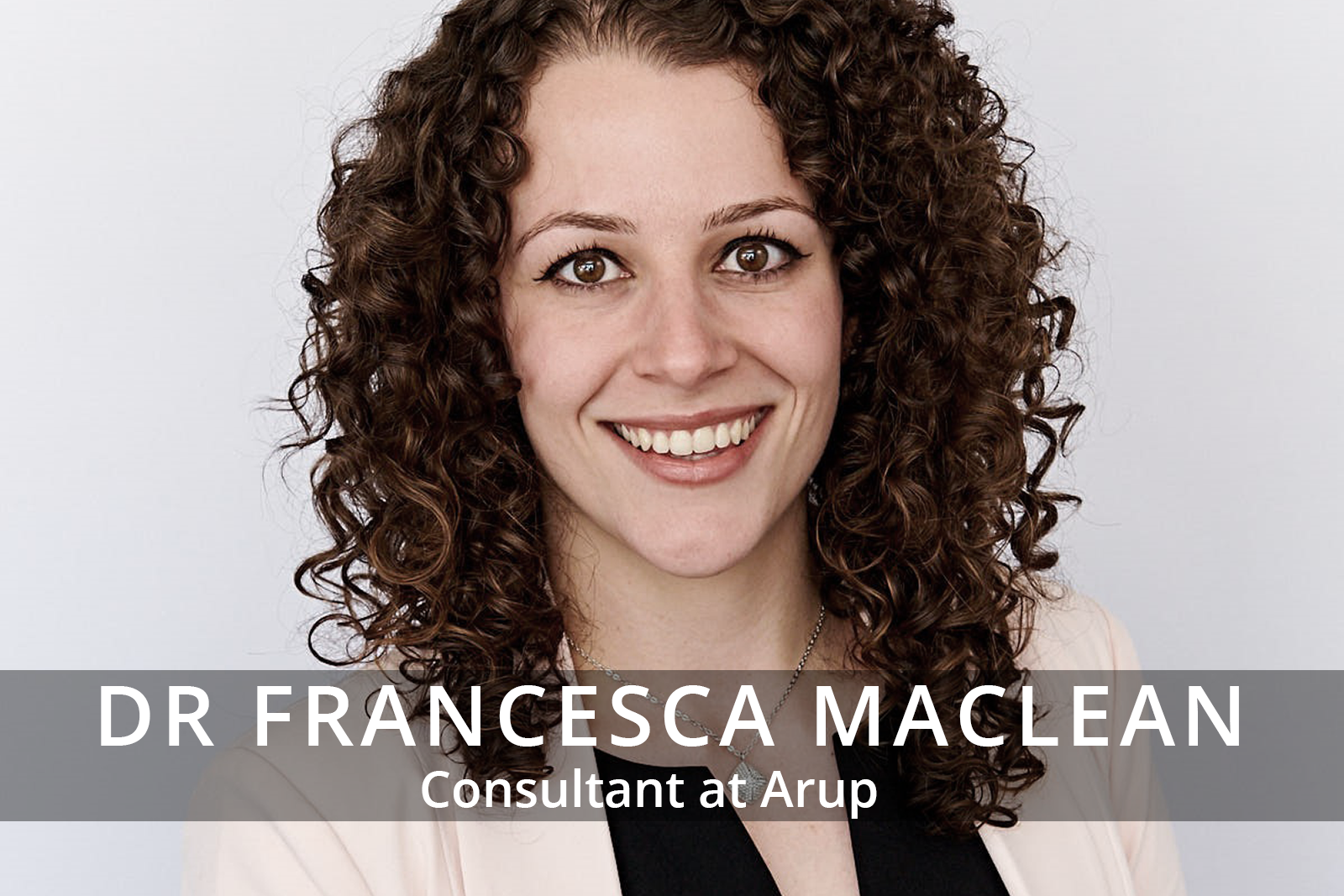 Female participants in a workshop sit in front of a graffiti wall.