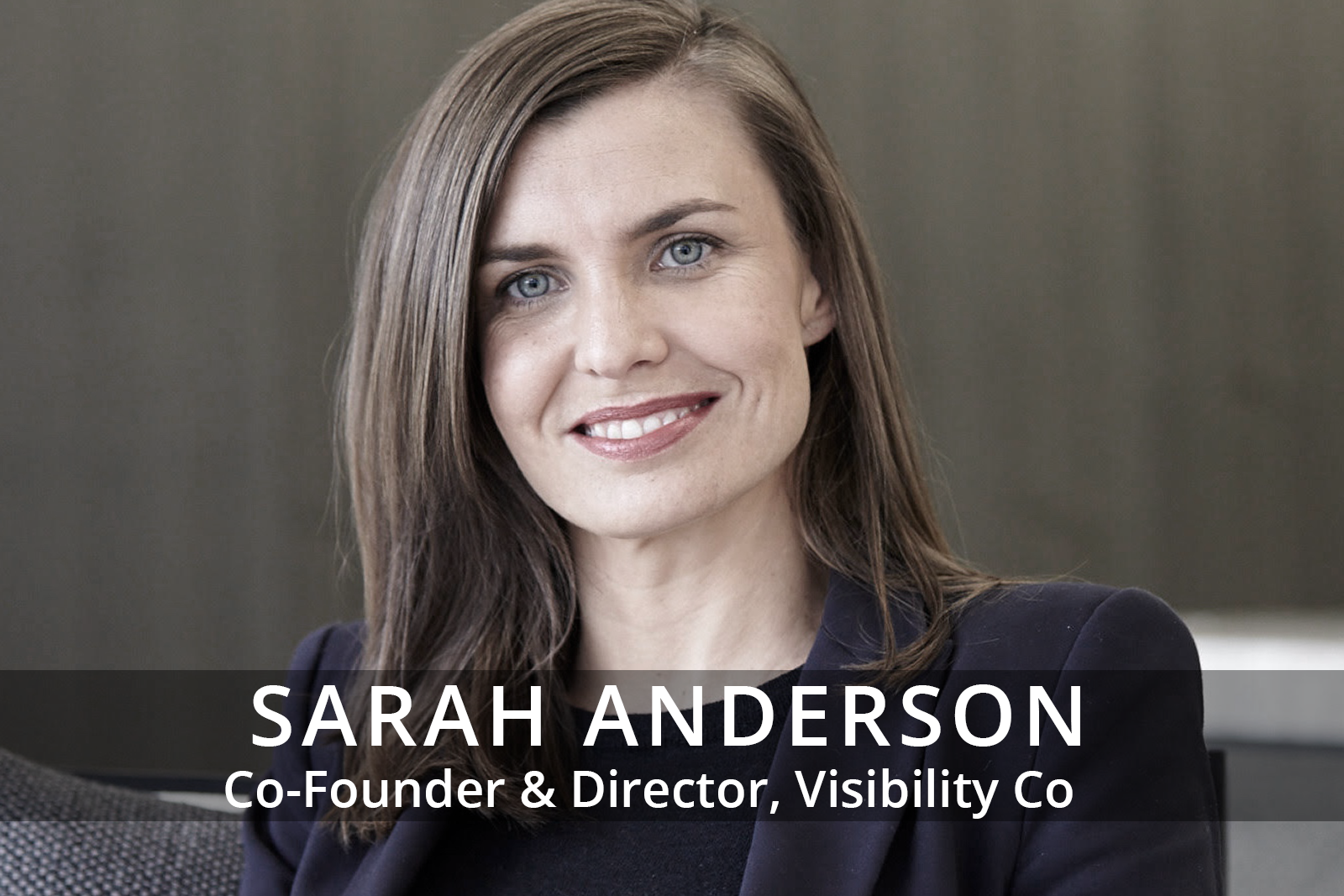 Female participants in a workshop sit in front of a graffiti wall.