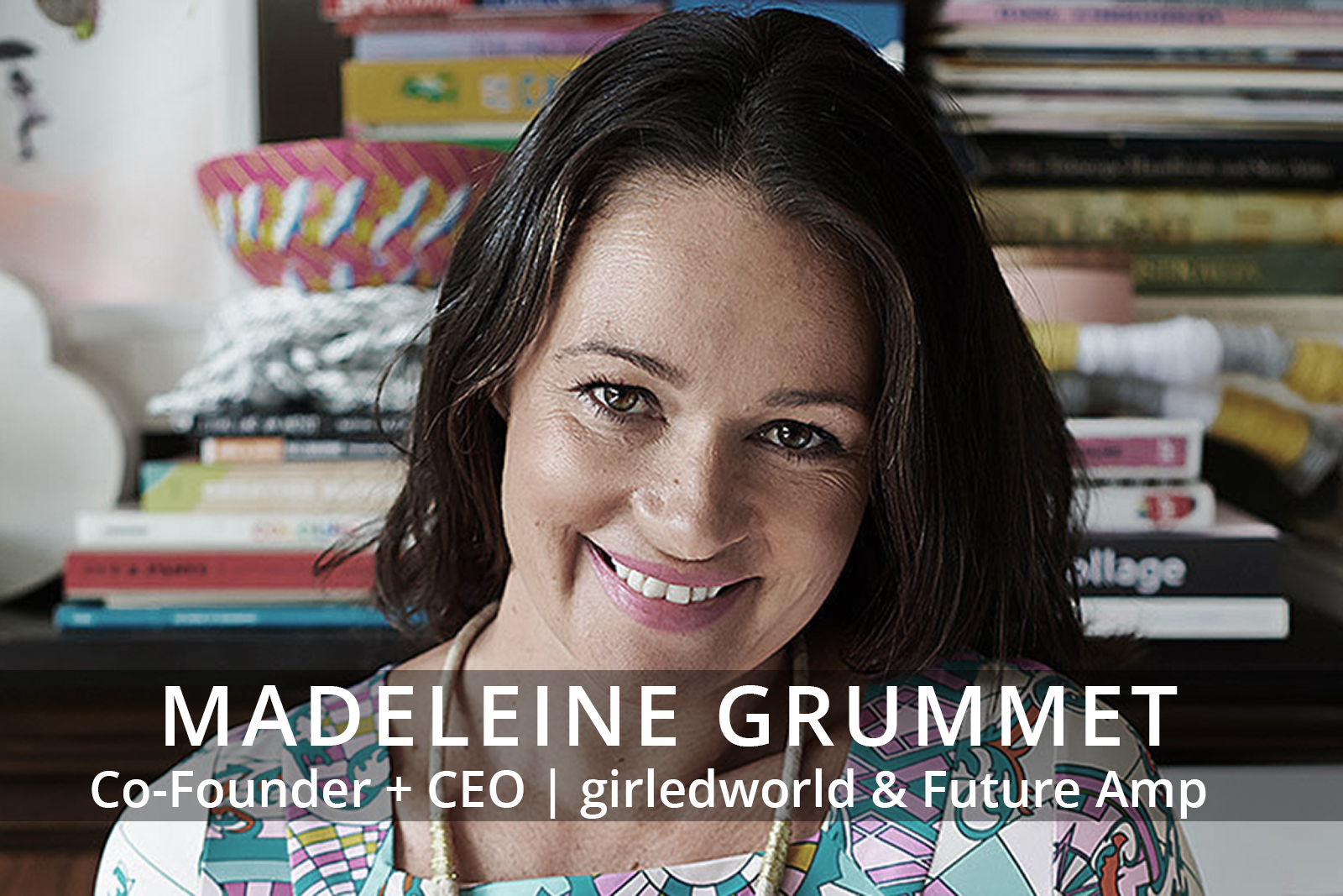 Female participants in a workshop sit in front of a graffiti wall.