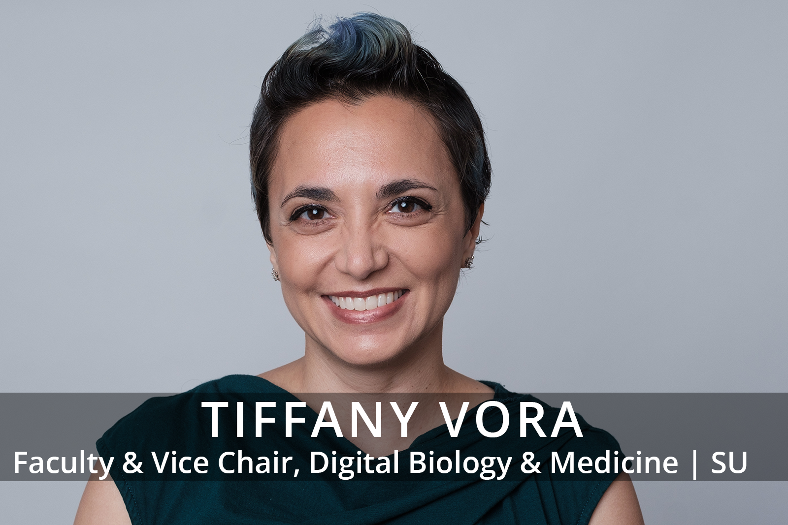 Female participants in a workshop sit in front of a graffiti wall.