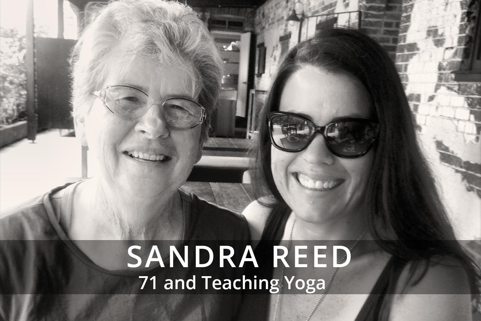 Female participants in a workshop sit in front of a graffiti wall.