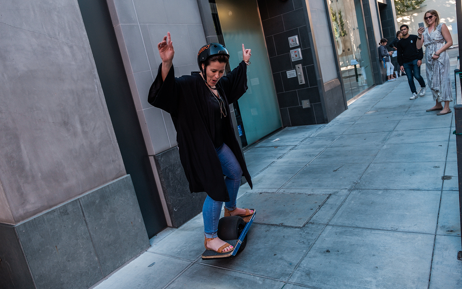 Female participants in a workshop sit in front of a graffiti wall.
