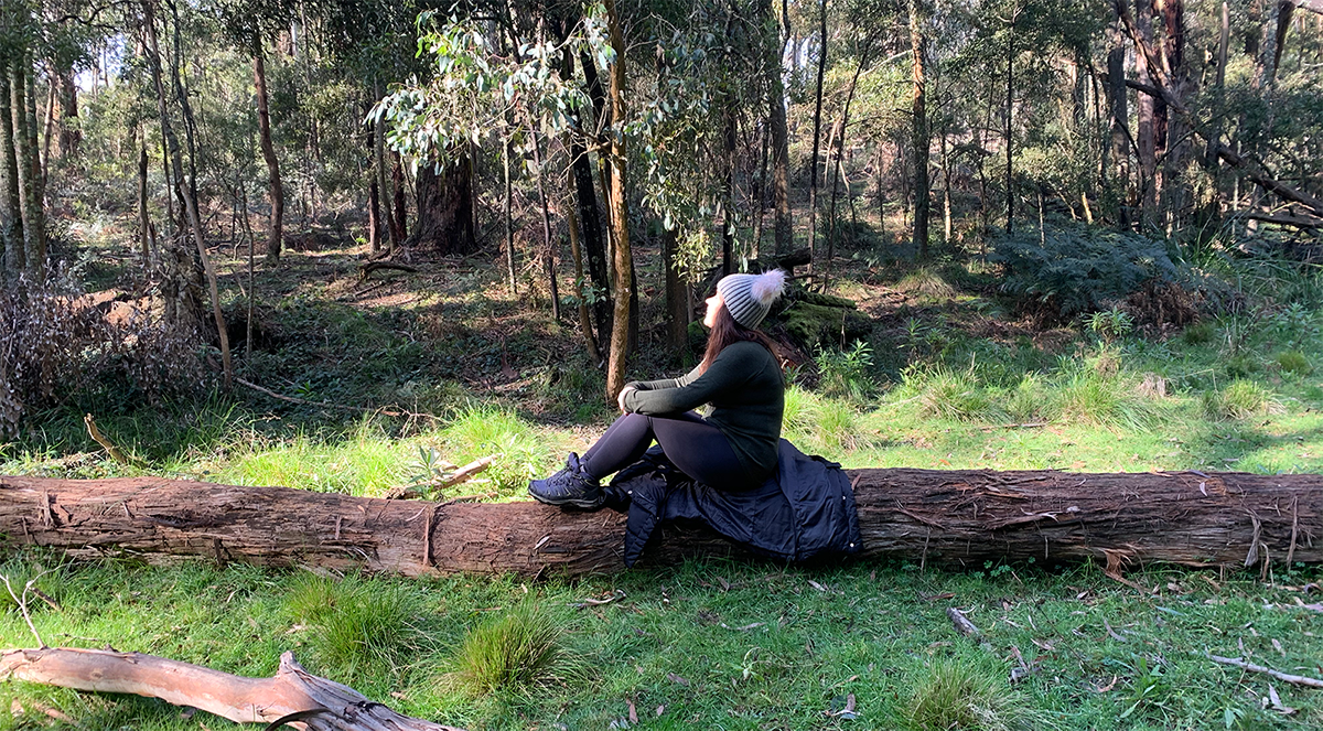 Female participants in a workshop sit in front of a graffiti wall.