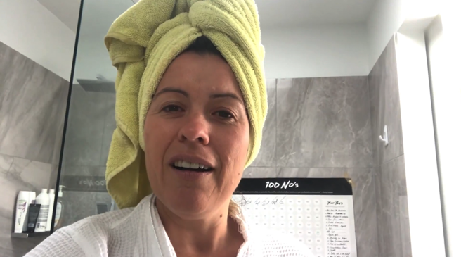 Female participants in a workshop sit in front of a graffiti wall.