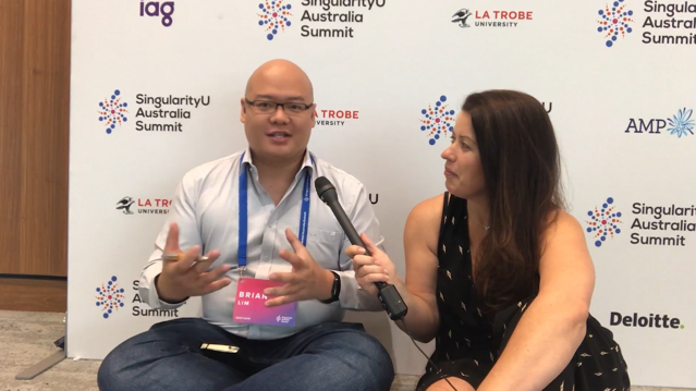 Female participants in a workshop sit in front of a graffiti wall.
