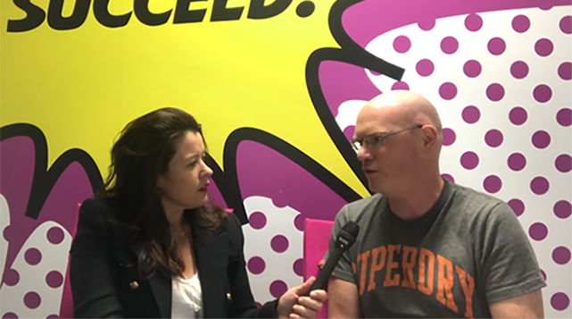 Female participants in a workshop sit in front of a graffiti wall.