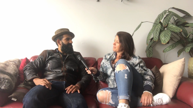 Female participants in a workshop sit in front of a graffiti wall.