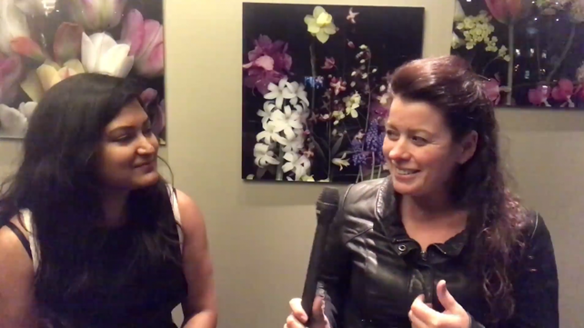 Female participants in a workshop sit in front of a graffiti wall.