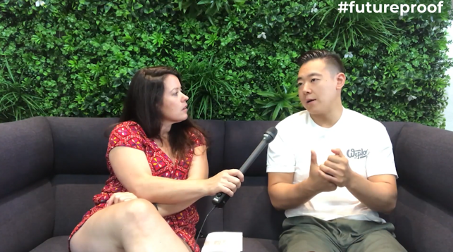 Female participants in a workshop sit in front of a graffiti wall.