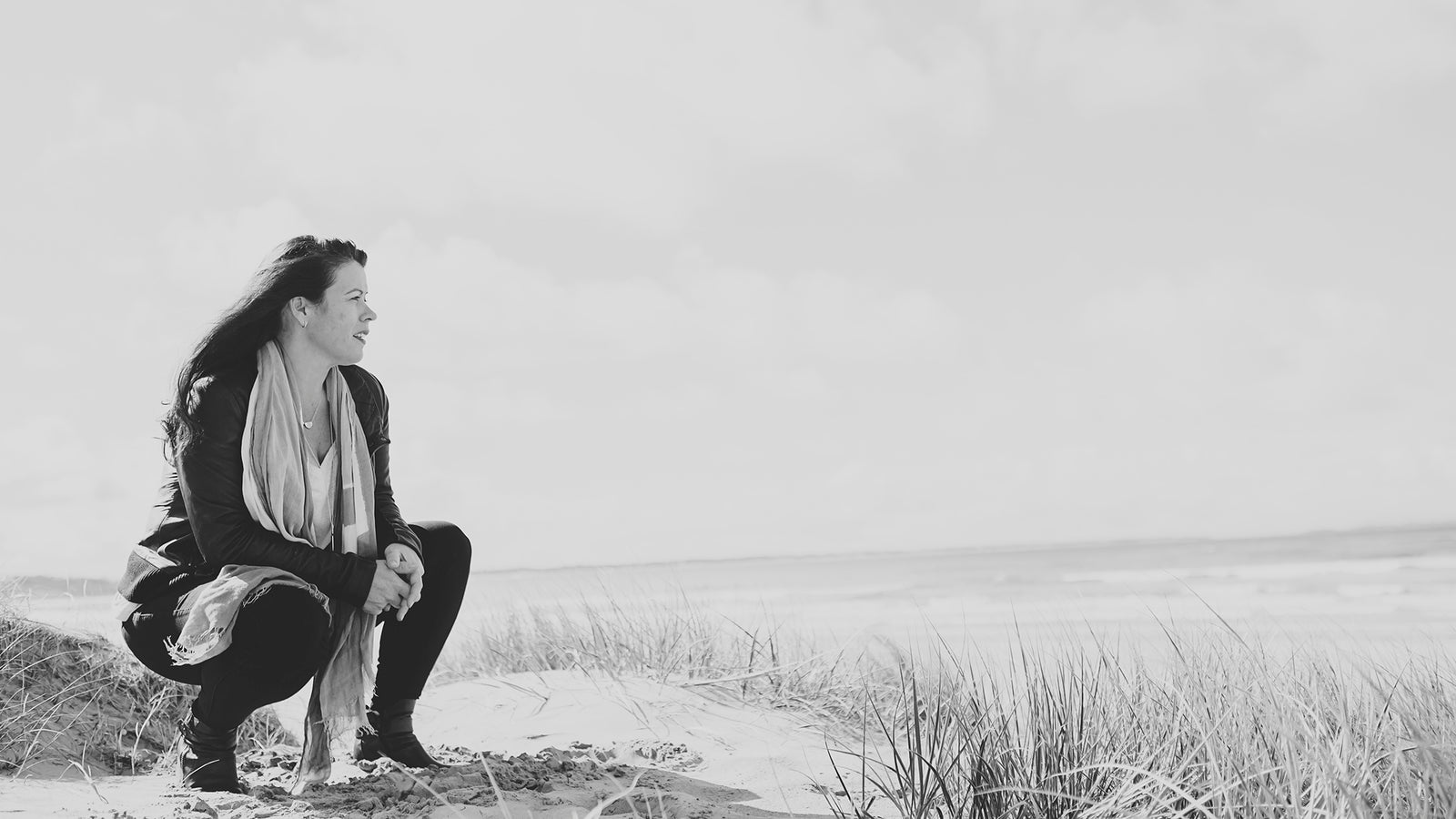 Female participants in a workshop sit in front of a graffiti wall.