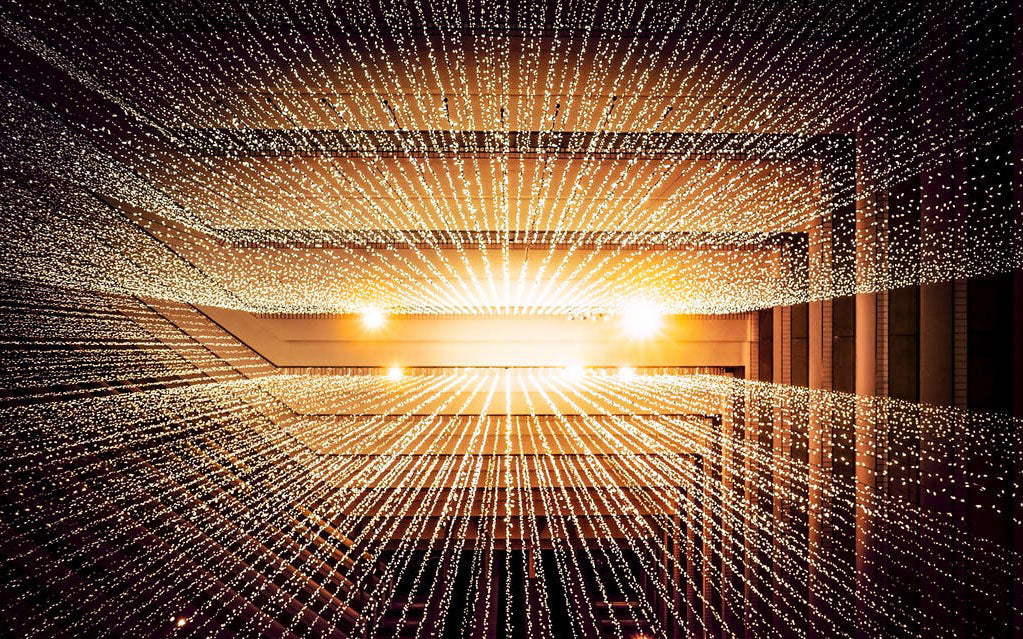 Female participants in a workshop sit in front of a graffiti wall.
