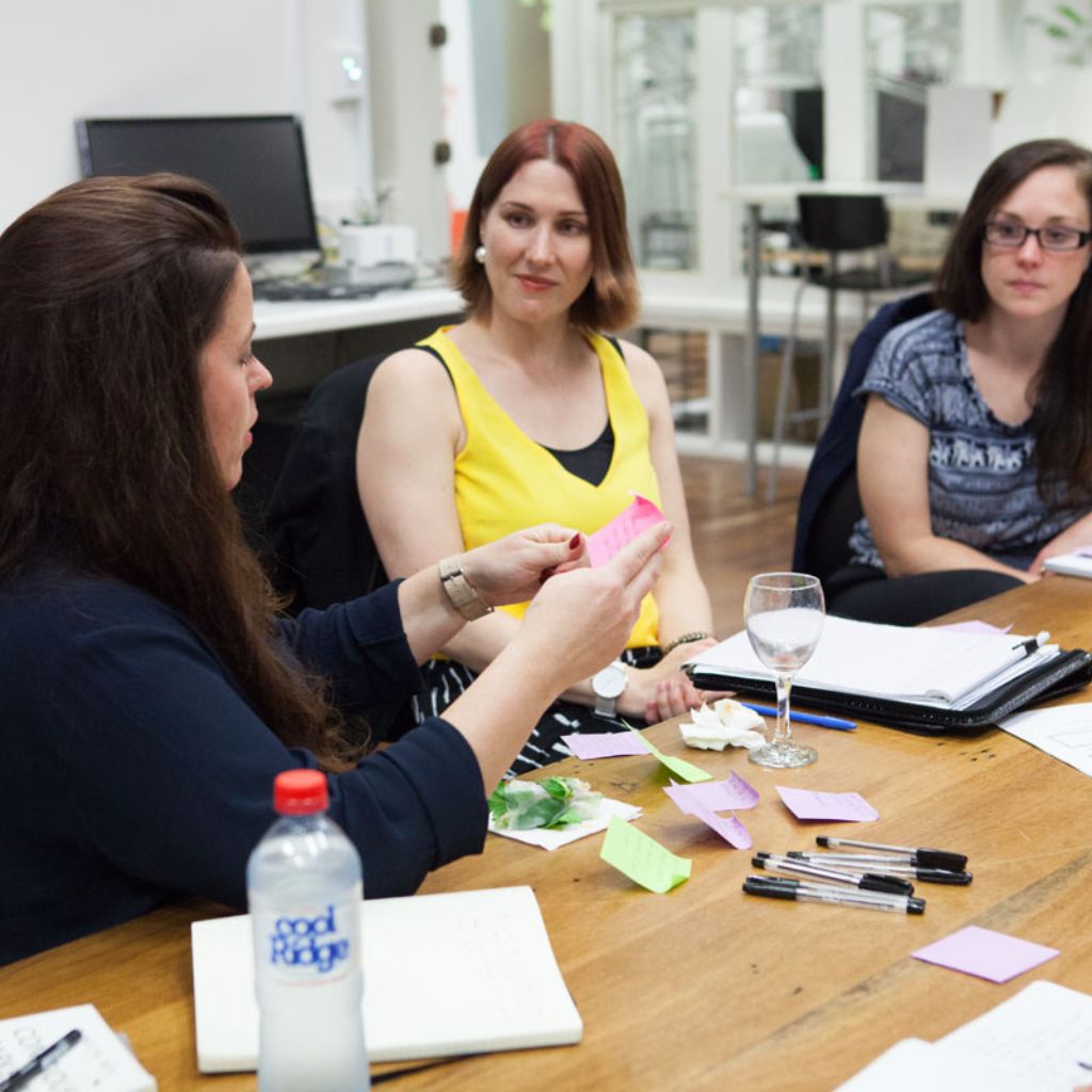 Woman facilitating a conversation with two other women.