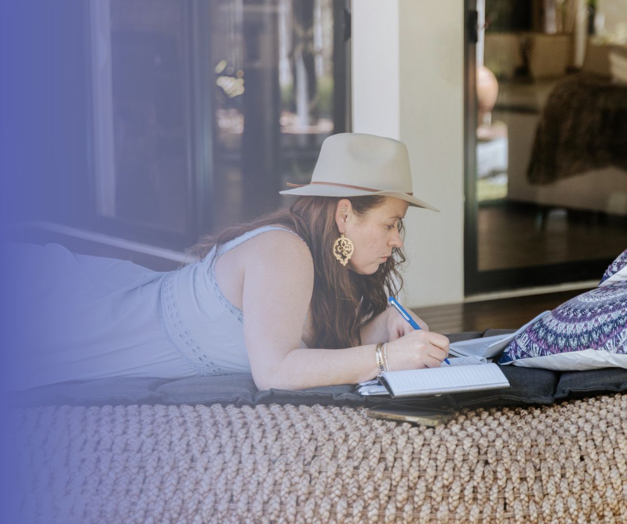Woman is journaling on a lounge chair.