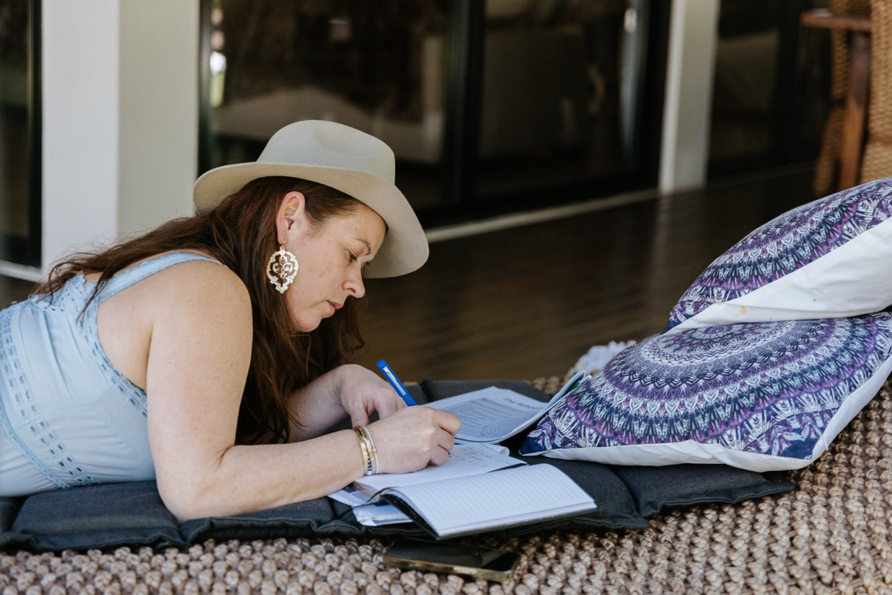 Penny laying down writing in her journal