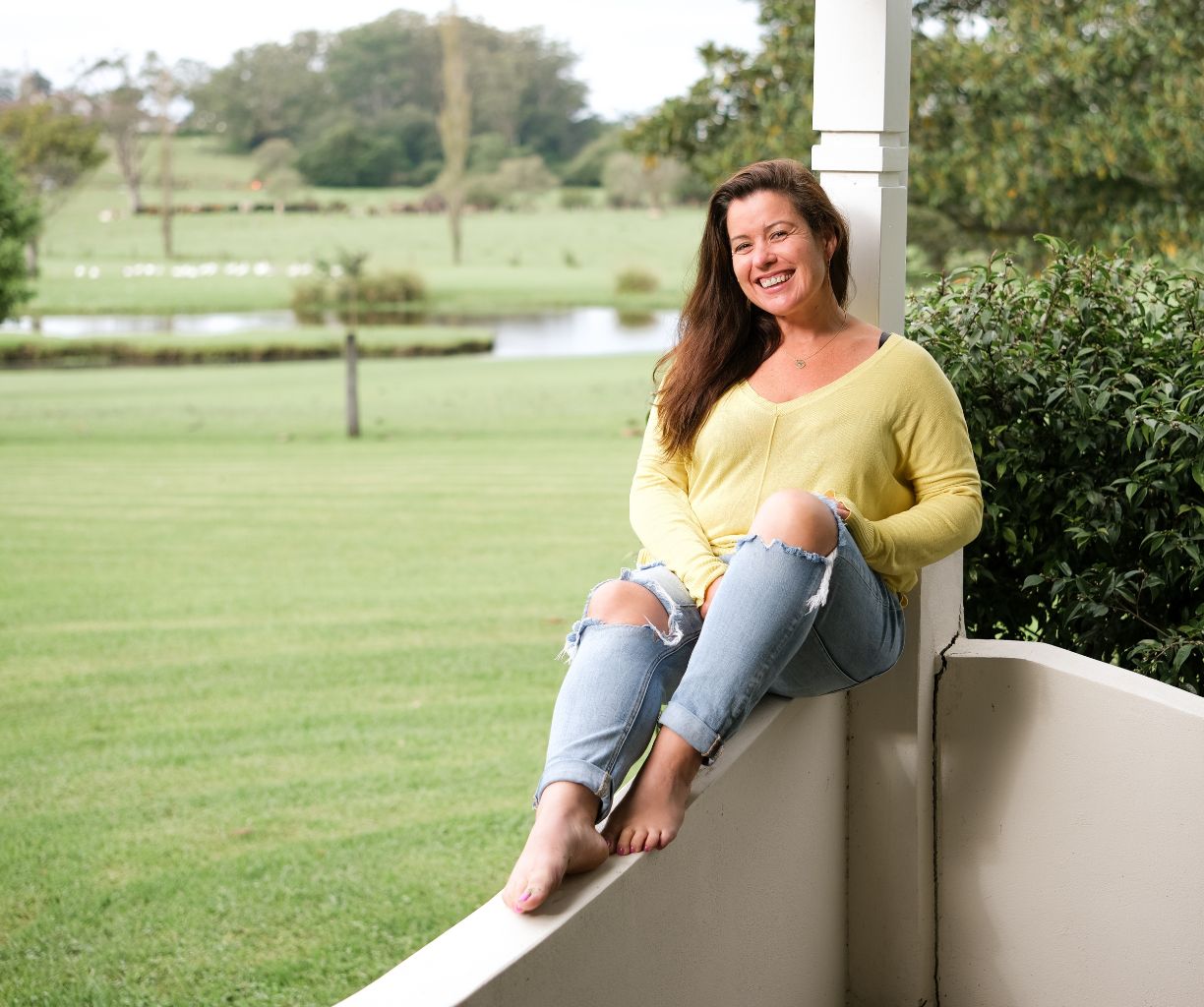 Woman is sitting on a short ledge.
