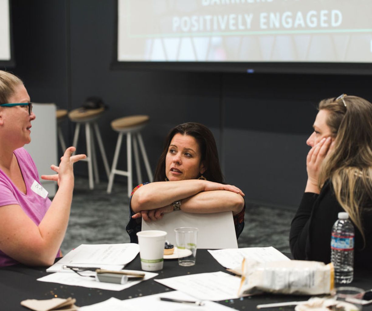 Woman facilitating a conversation with two other women.